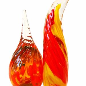 Two colorful glass sculptures with swirling red, yellow, and orange patterns on a white background.