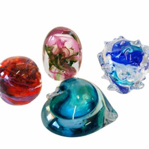 Colorful glass paperweights in different shapes on a white background.