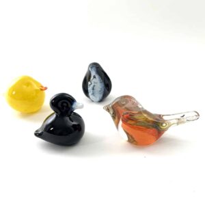 Four colorful glass bird figurines on a white background.