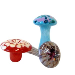 Three colorful ceramic mushrooms on a white background.