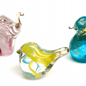 Three colorful glass animal figurines on a white background.