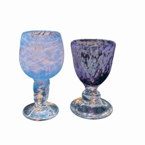 Two colorful glass chalices, one blue and one purple, on a white background.